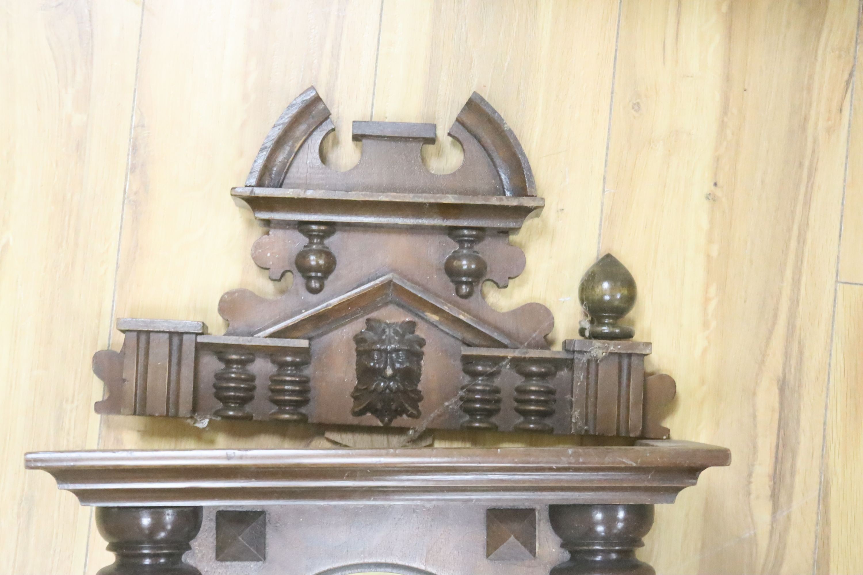 A 19th century Continental wall clock, in architectural walnut case, with key and pendulum, 95cm